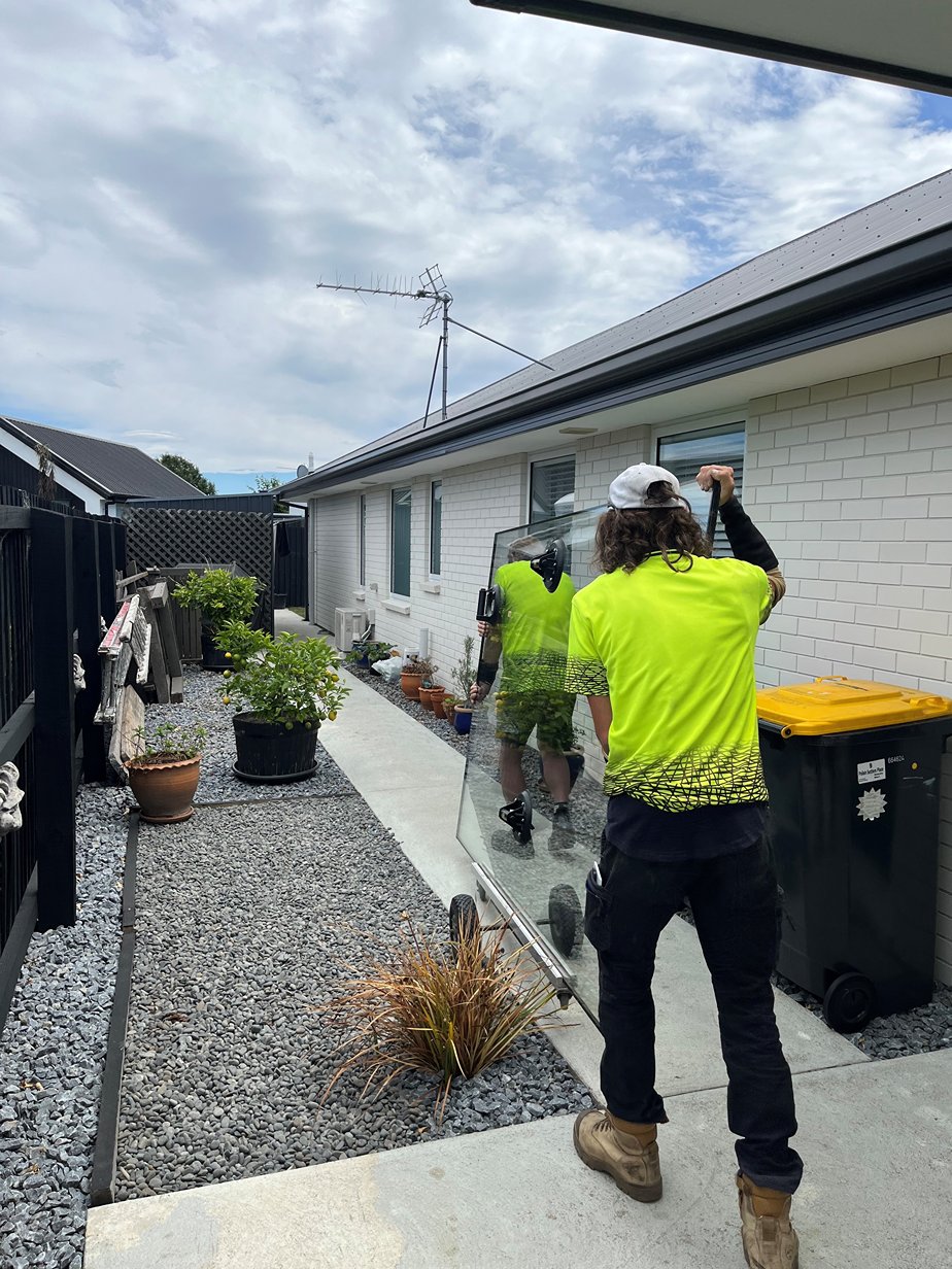 Sharp Glass contractor fixing and measuring up a glass window